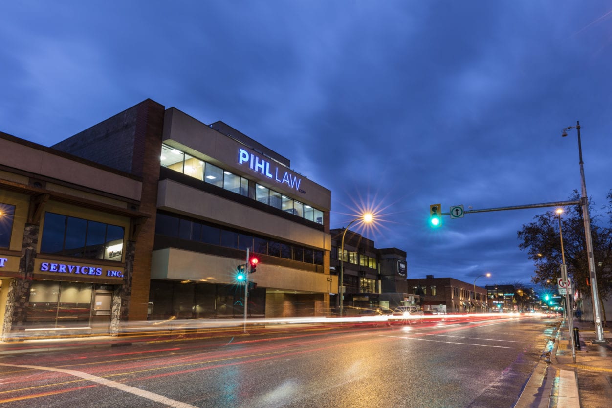 Pihl Law Office Building at Night with traffic light flares and wet road
