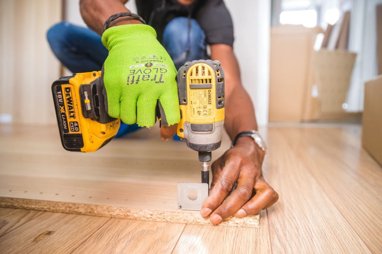 carpenter contractor working in a house closeup of hands on a drill, highlighting Tenant Created Builder's Liens for unpaid work on a rented property