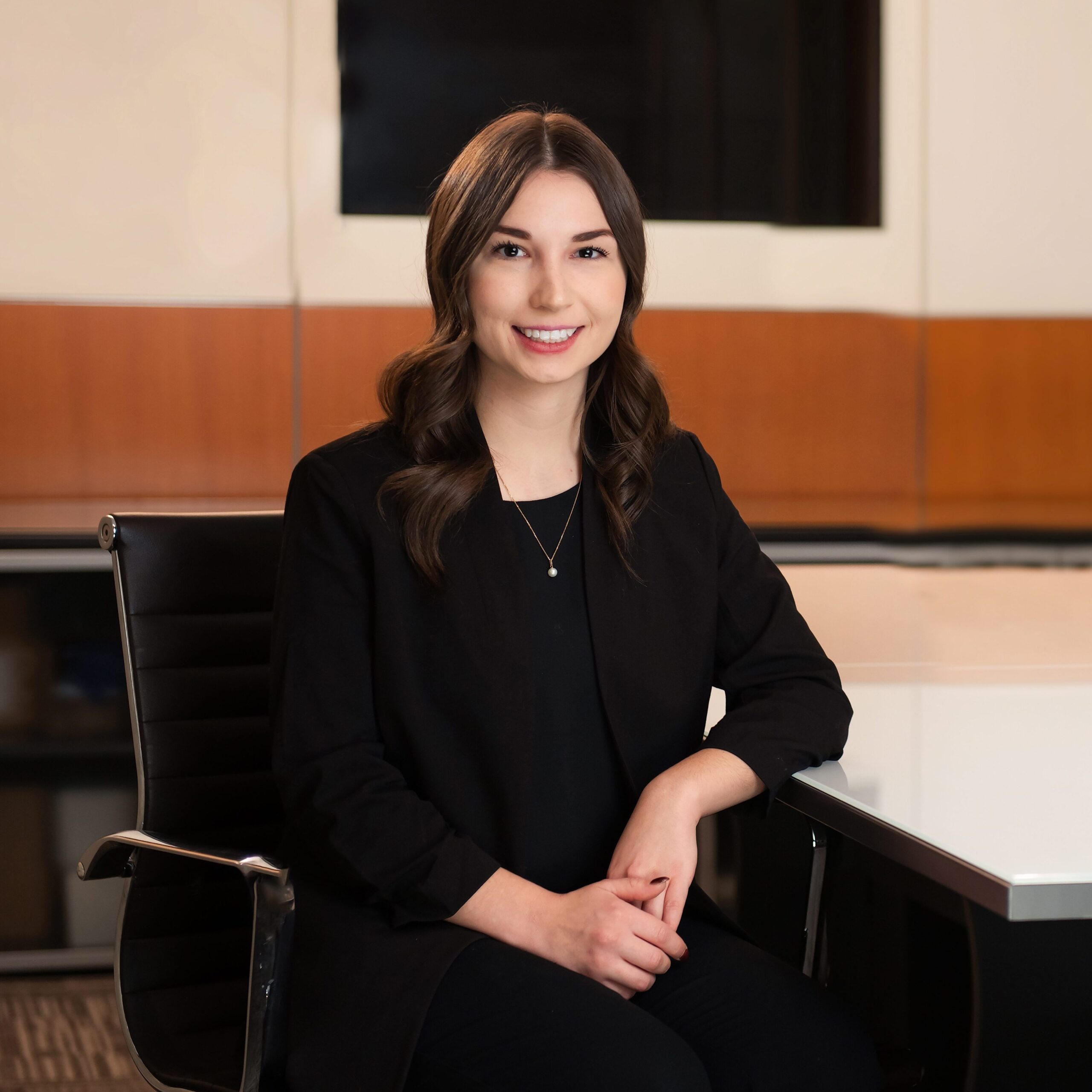 Danielle Tataryn seated at a table for her professional headshot for Pihl Law in Kelowna, BC.