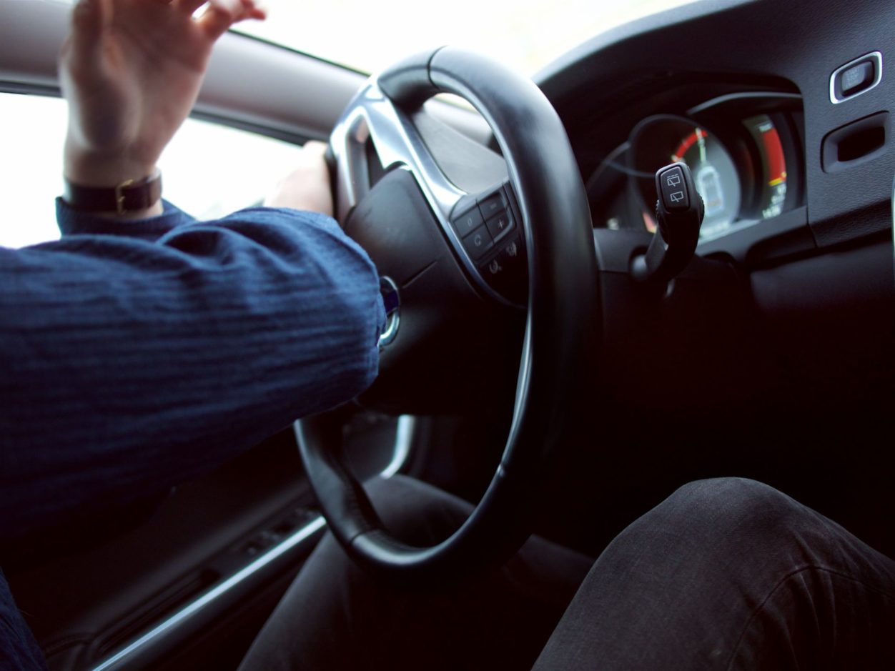 closeup of a woman's hands holding onto a black steering wheel of a vehicle