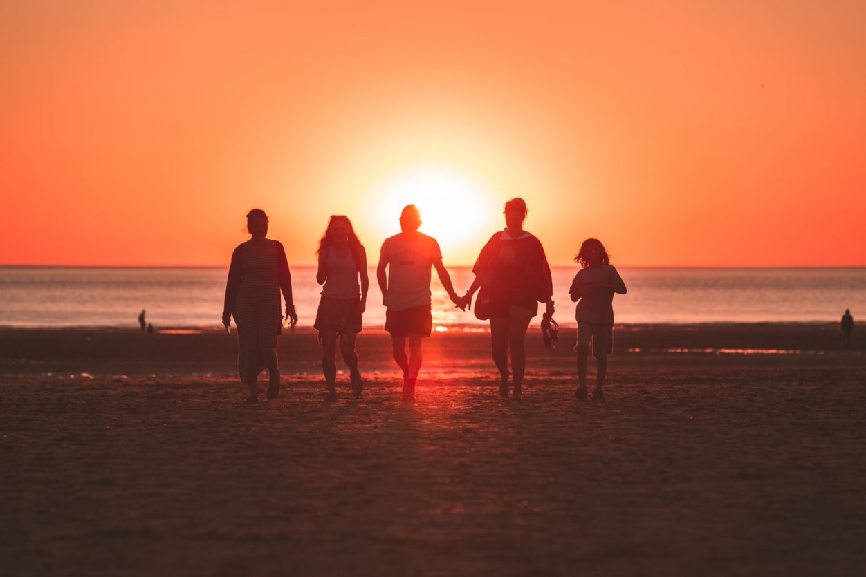 A family with sunset in the background.