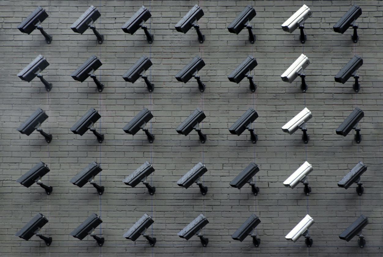 a wall of black and silver outdoor cameras, highlighting privacy in the workplace