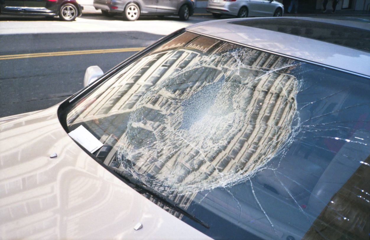 a closeup of a parked car windshield after a vehicle accident smashed in