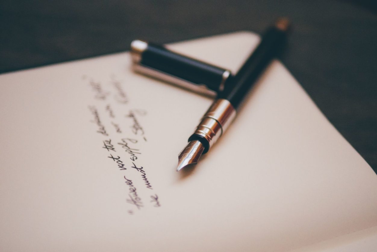 a closeup of a pen and last will testament contract